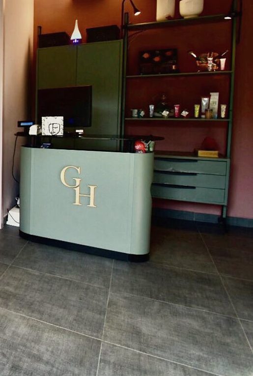 Il bancone di accoglienza con il monogramma GH dorato e gli scaffali dei prodotti